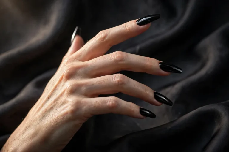 Woman's hand with long coffin-shaped jet-black glossy nails — black nail designs fall 2026