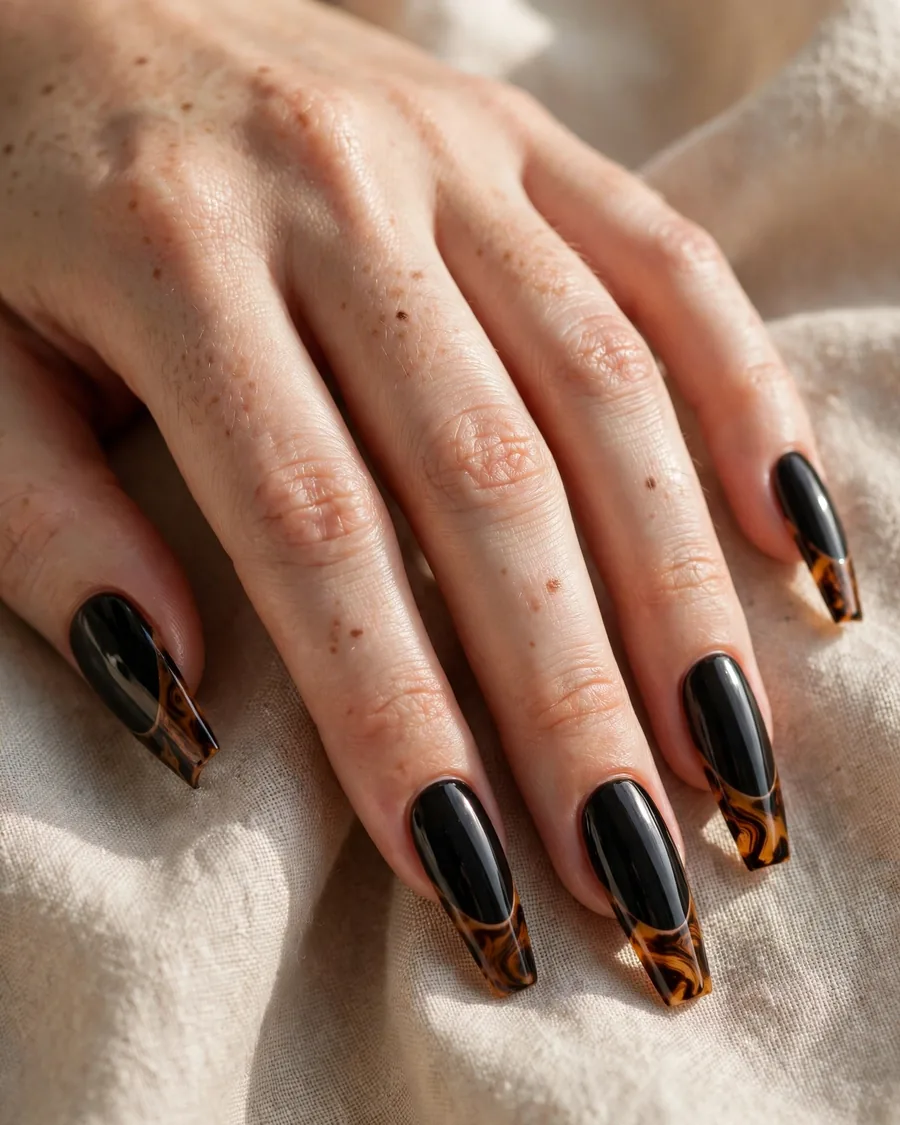 Jet-black nails with amber tortoise-shell French tips