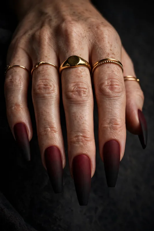 Matte black-cherry ombré nails fading from wine burgundy to near-black on coffin nails