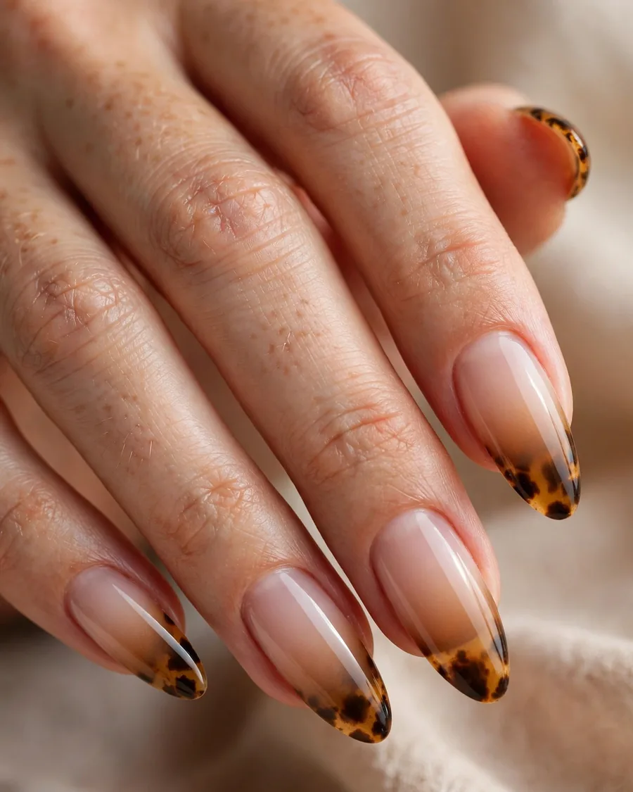 Tortoiseshell ombre nails fading from amber tips to nude cuticles